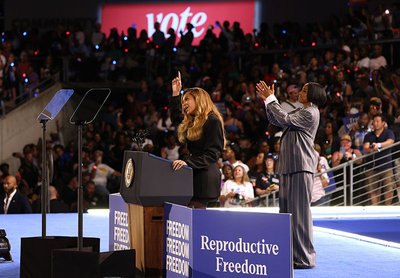 HOUSTON, TEXAS - OCTOBER 25: Recording artist Beyonce (L) speaks as Kelly Rowland (R) looks on during a campaign rally with Democratic presidential candidate, U.S. Vice President Kamala Harris, at Shell Energy Stadium on October 25, 2024 in Houston, Texas. Vice President Kamala Harris is campaigning in Texas holding a rally supporting reproductive rights with recording artists Beyonce and Willie Nelson.  (Photo by Justin Sullivan/Getty Images)