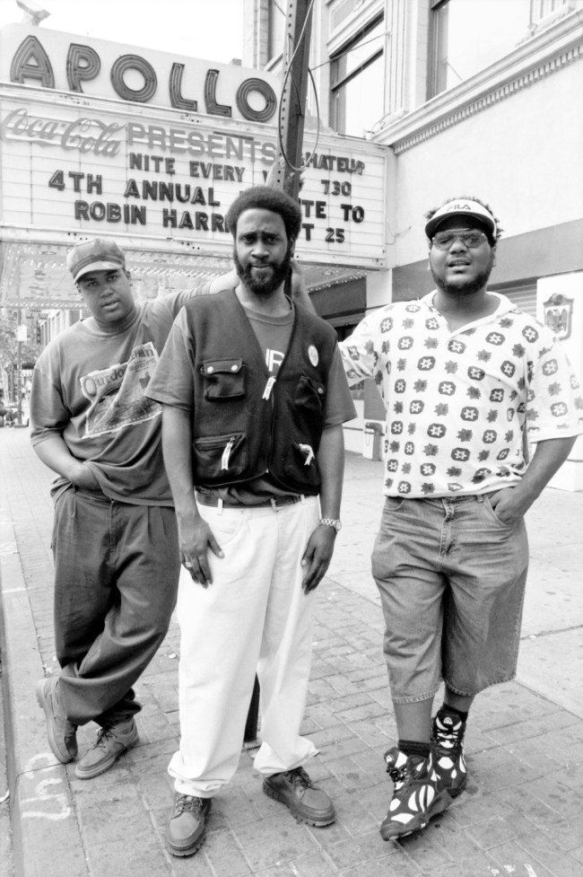 NEW YORK CITY - SEPTEMBER 1993: David Jude Jolicoeur aka Trugoy the Dove aka Dave aka Plug Two (wearing gray), Kevin Mercer aka Posdnuos aka Mercenary aka Plug Wonder Why aka Plug One (wearing black vest) and Vincent Mason aka P.A. Pasemaster Mase aka Maseo aka Plug Three (wearing pattern shirt and shorts) of the hip hop trio De La Soul pose for a portrait outside the Apollo Theater in Harlem in September 1993 in New York City, New York. (Photo by David Corio/Michael Ochs Archives/Getty Images)