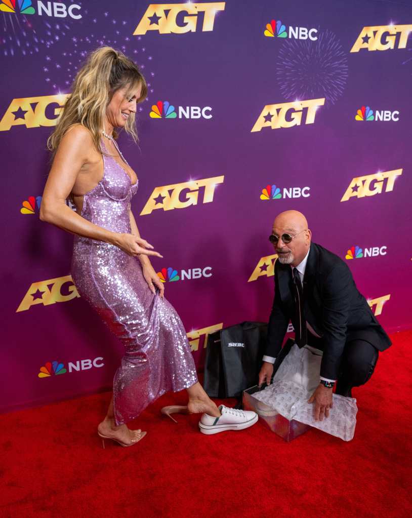 Howie Mandel gifts Heidi Klum a pair of Skechers on the "America's Got Talent" Season 19 finale red carpet.